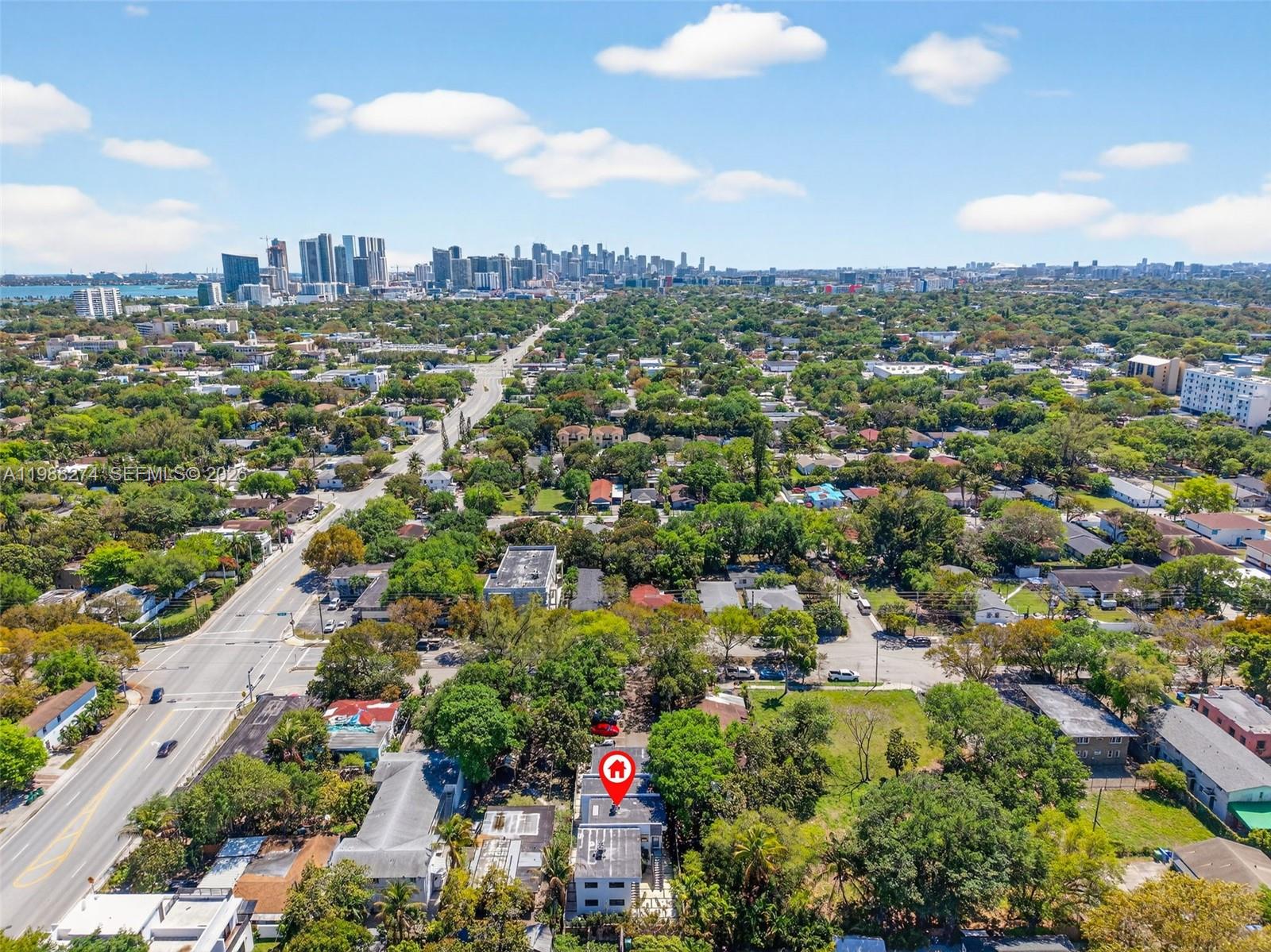An aerial view shows a residential building marked with a red pin amidst lush greenery — 37 NW 59th St # 4, Miami FL 33127, MIAMI, FL