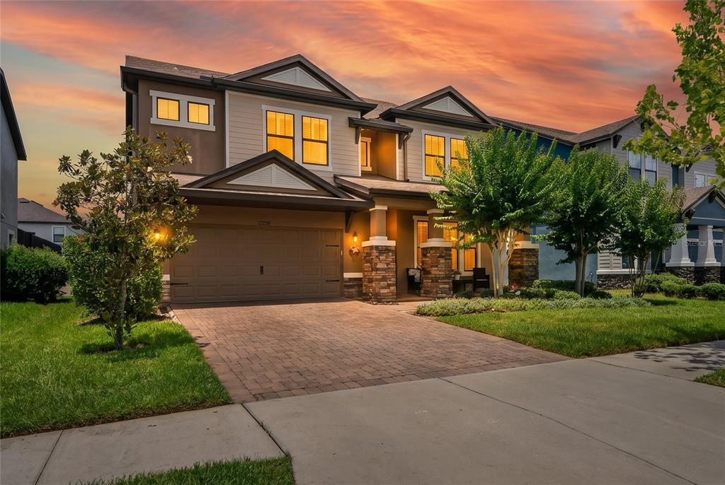 A two-story suburban house with a stone-accented porch, a paved driveway, and a garage — 12299 LAKE BLANCHE DRIVE, ODESSA, FL