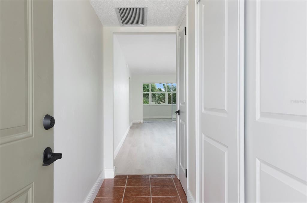 A tiled entryway leads into a hallway with light-colored flooring and a view of windows — 1225 58TH STREET N UNIT 203A, ST PETERSBURG, FL
