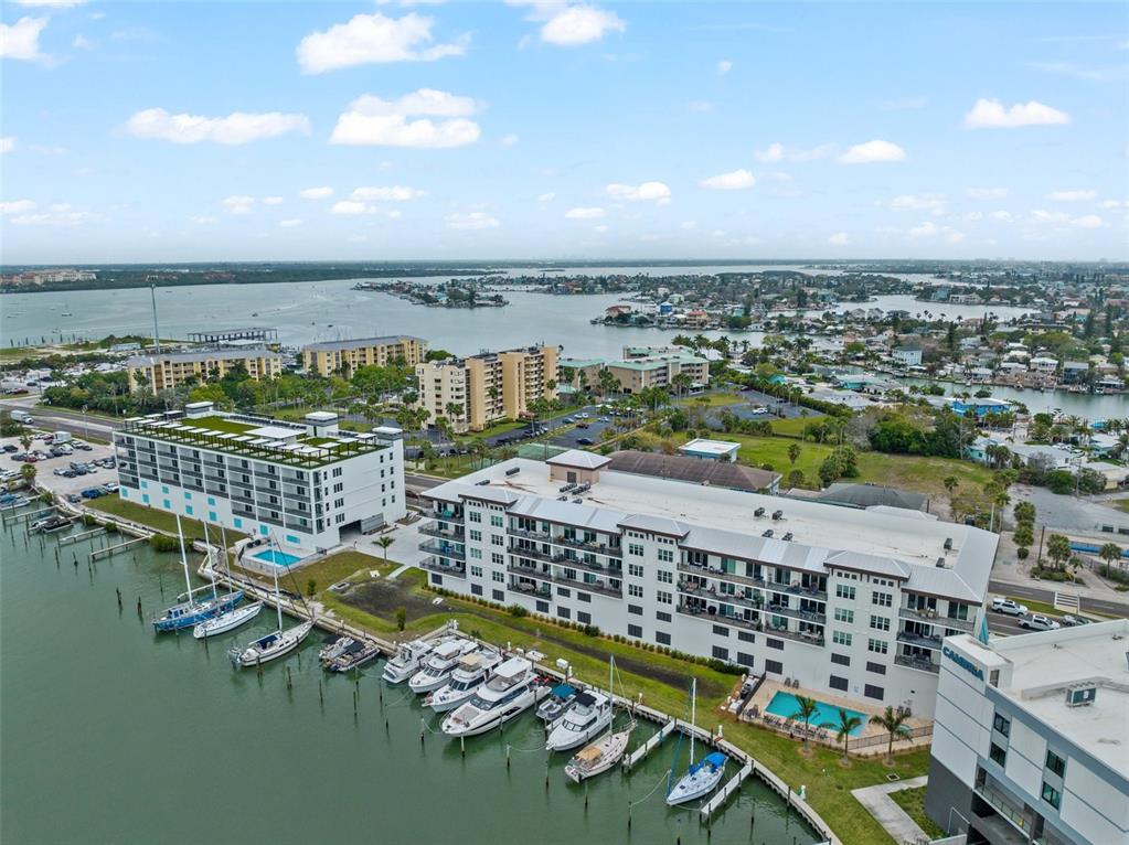 An aerial view shows a waterfront hotel complex with a marina and swimming pools — 300 150TH AVENUE UNIT 510, MADEIRA BEACH, FL