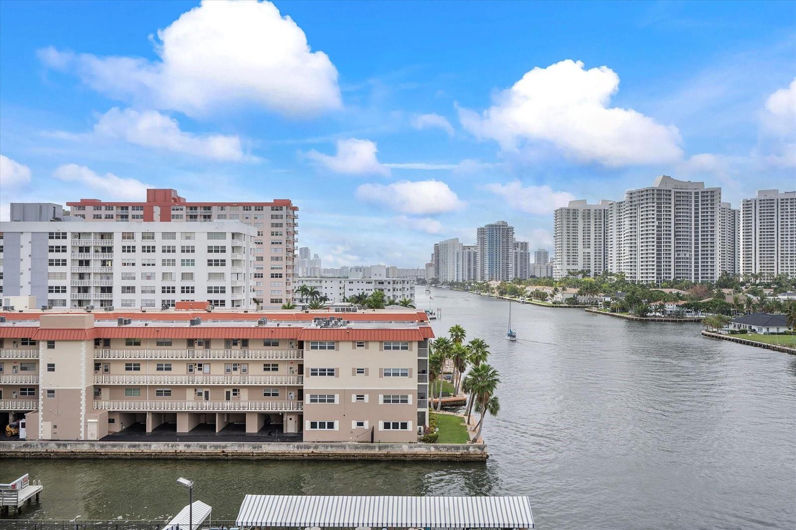 An elevated view of a waterway lined with apartment buildings and high-rise condominiums under clouds — 2017 S Ocean Drive # 710, Hallandale Beach FL 33009, HALLANDALE BEACH, FL