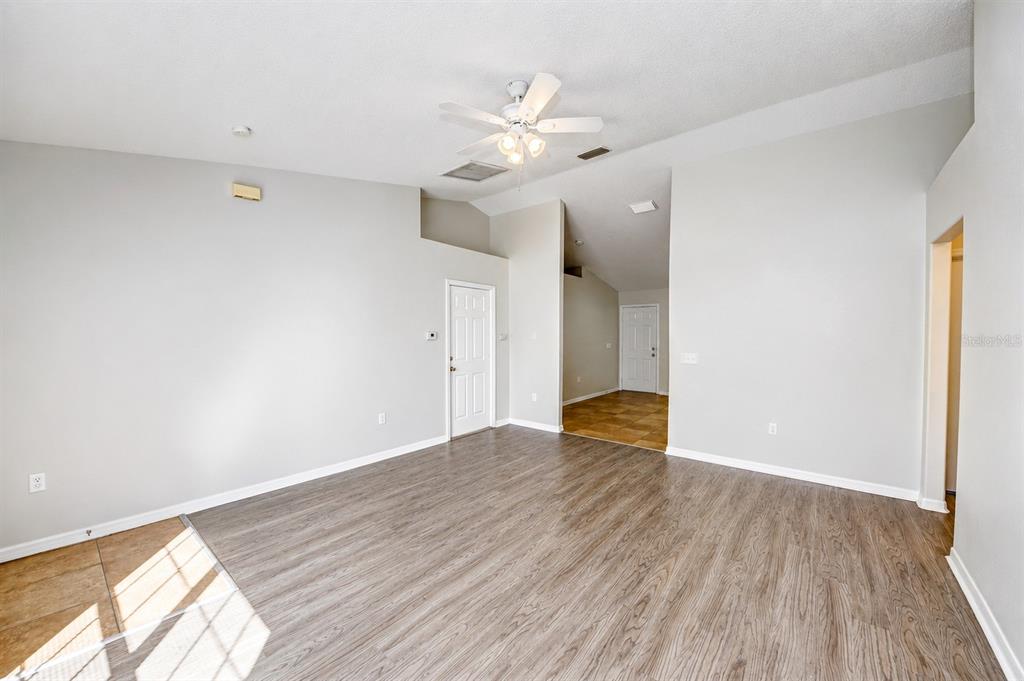 A living room with light gray walls, wood-look flooring, and a white ceiling fan — 441 DANUBE DRIVE, KISSIMMEE, FL