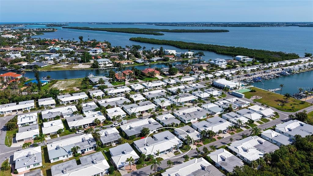 An aerial view of a residential neighborhood with a circled single-story house near water — 711 SPANISH DRIVE S, LONGBOAT KEY, FL