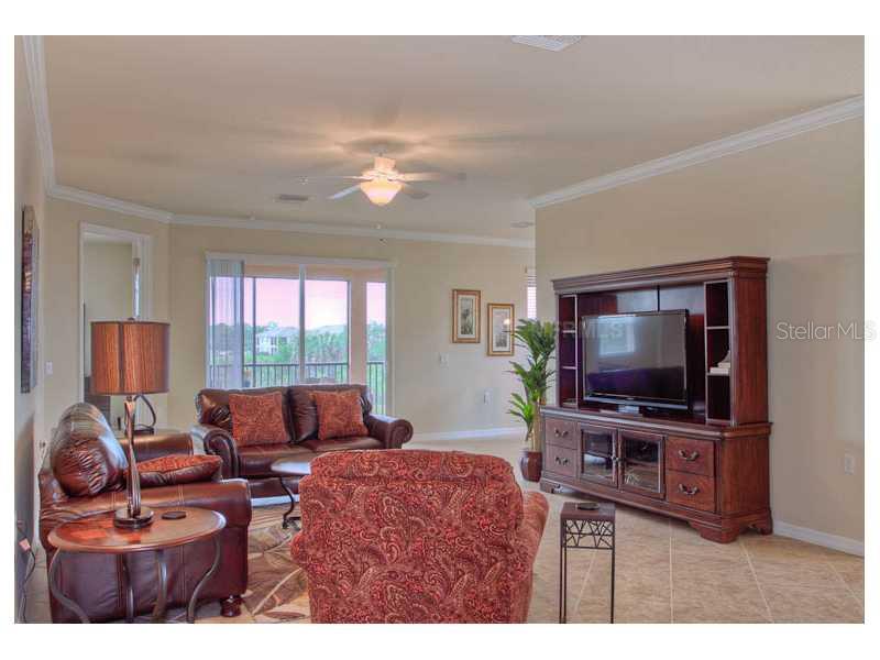 A living room features leather furniture, a large wooden entertainment center, and a ceiling fan — 7312 RIVER HAMMOCK DRIVE UNIT 103, BRADENTON, FL
