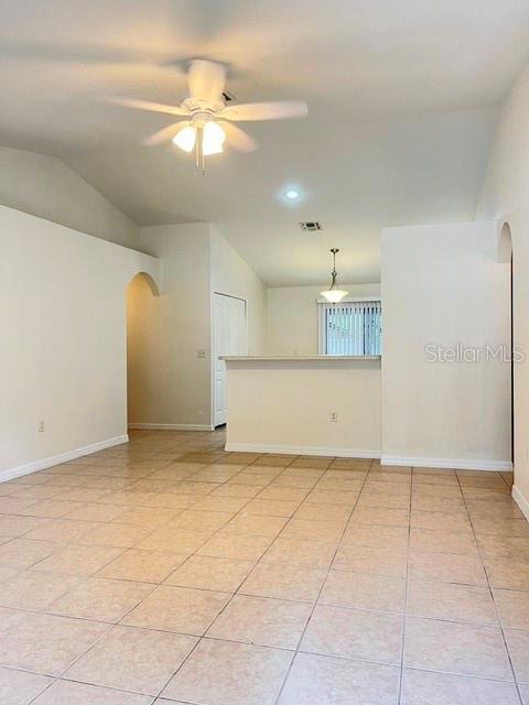An open-concept living area features light-colored tile flooring, a ceiling fan, and a breakfast bar — 733 E INDIANA AVENUE, DELAND, FL