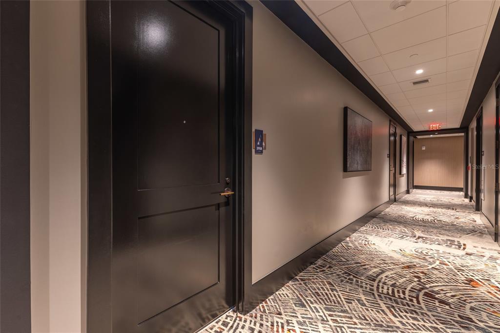 A hallway with a black door, patterned carpet, and recessed ceiling lights — 275 1ST AVENUE S UNIT 3908, ST PETERSBURG, FL