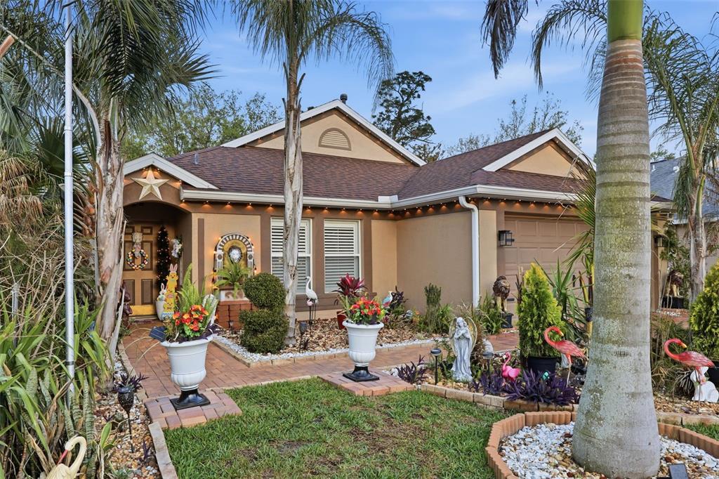 A single-story house with a brown roof, tan stucco exterior, and a landscaped front yard — 2848 DOE RUN TRAIL, ORANGE CITY, FL