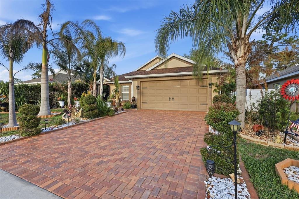 A single-story house with a tan exterior, a paved driveway, and several palm trees — 2848 DOE RUN TRAIL, ORANGE CITY, FL