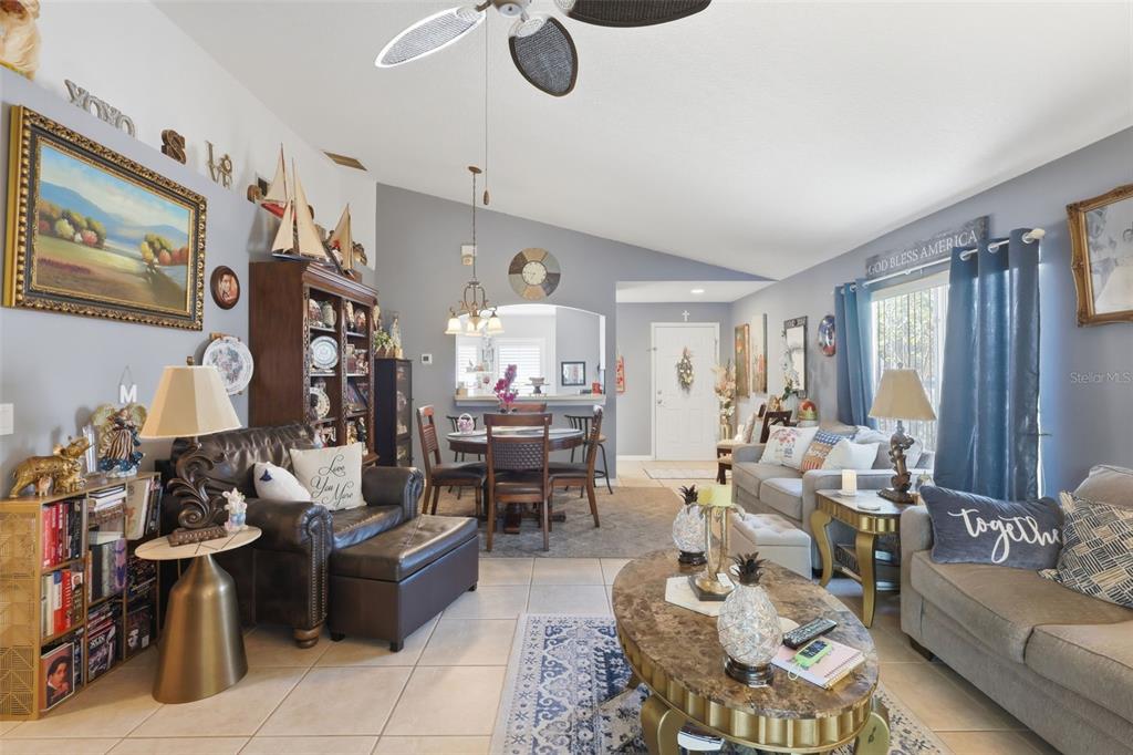 A living room features tile flooring, a leather armchair, a sofa, and a dining area — 2848 DOE RUN TRAIL, ORANGE CITY, FL