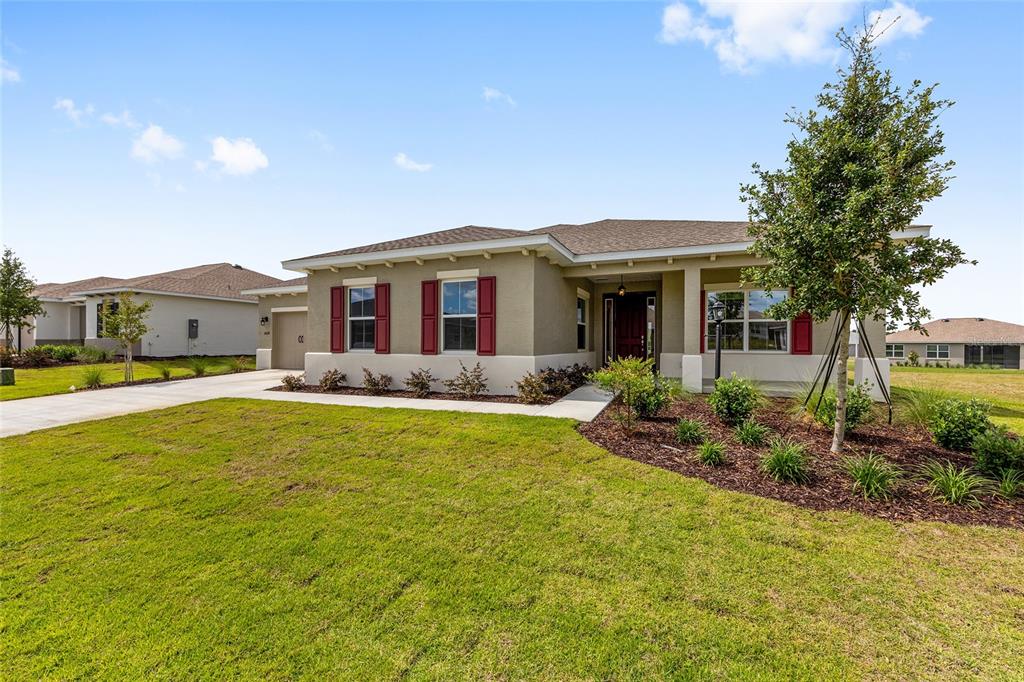 A single-story house with a tan exterior, red shutters, and a front lawn — 10618 SW 101ST LANE ROAD, OCALA, FL