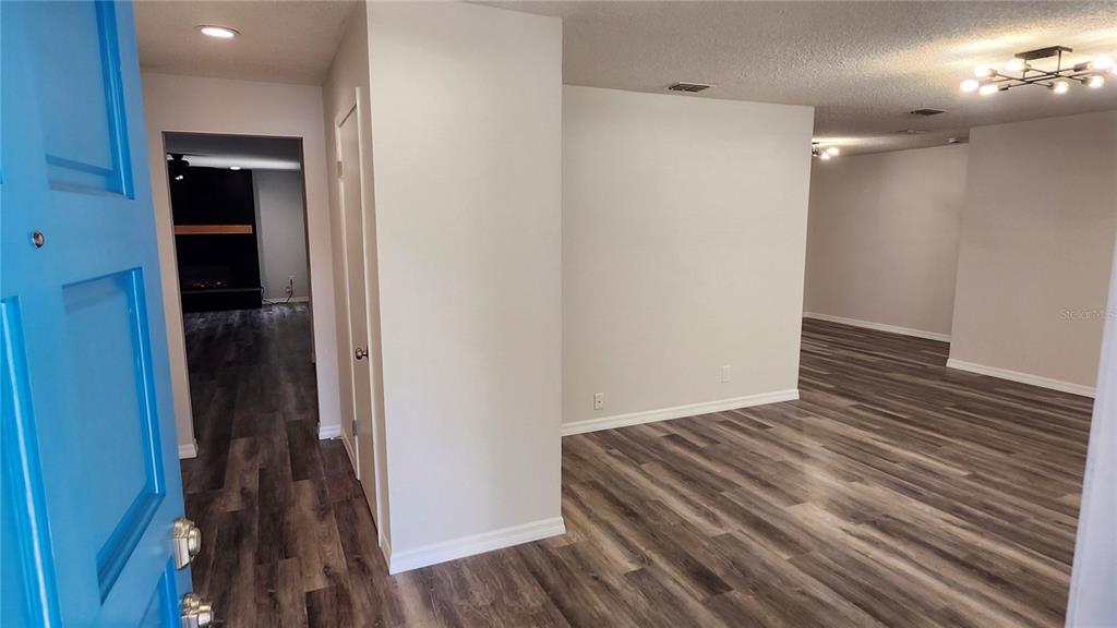 An entryway opens into a living area with gray wood-look flooring and white walls — 8531 PORT SAID STREET, ORLANDO, FL
