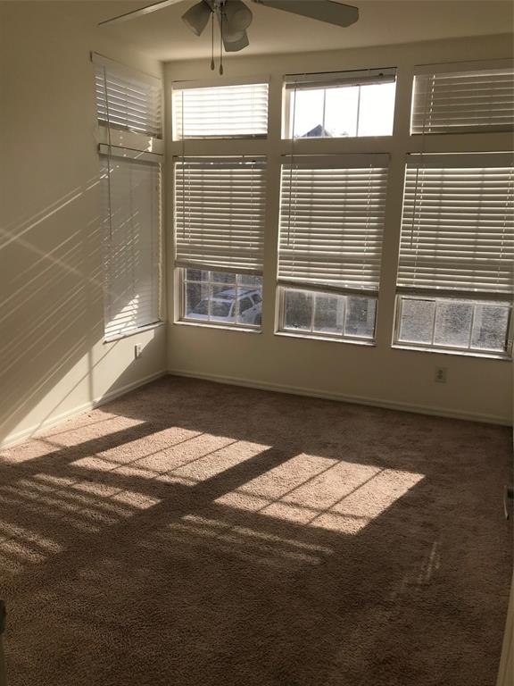 An empty room with beige carpet, a ceiling fan, and large windows with white blinds — 7635 PLANTATION CIRCLE UNIT 7635, BRADENTON, FL