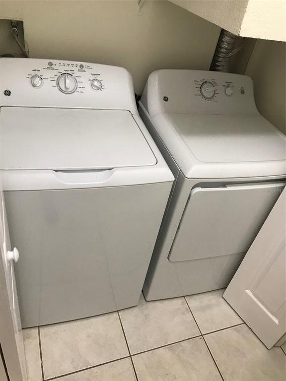 A laundry closet containing a white top-loading washing machine and a matching dryer — 7635 PLANTATION CIRCLE UNIT 7635, BRADENTON, FL