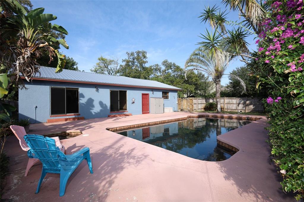 A blue house with a metal roof overlooks a backyard swimming pool and patio area — 921 ELDRIDGE STREET, ORLANDO, FL