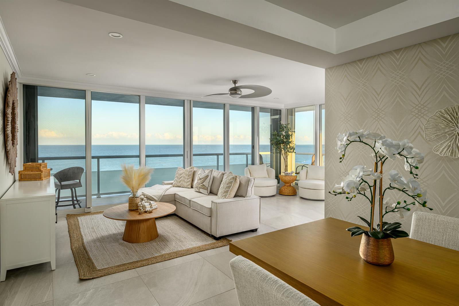 A living and dining area features floor-to-ceiling windows with an ocean view and neutral furniture — 3554 Ocean Drive, Vero Beach FL 32963, VERO BEACH, FL