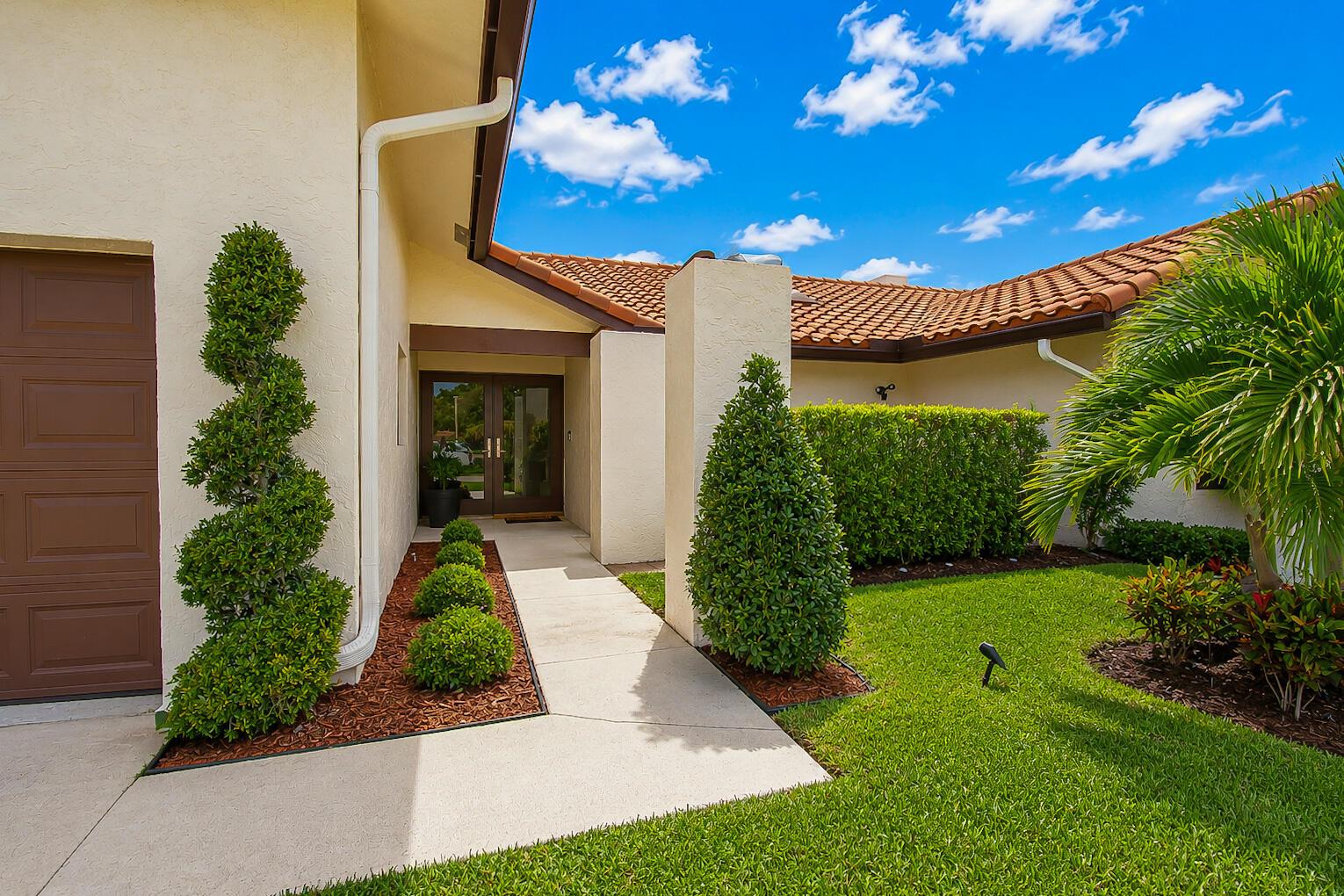 A concrete walkway leads to the front entrance of a house with a tiled roof — 22209 Morning Glory Terrace, Boca Raton FL 33433, BOCA RATON, FL