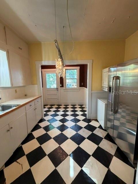 A kitchen with white cabinets, a black and white checkered floor, and a crystal chandelier — 1255 SE SILVER SPRINGS PLACE, OCALA, FL
