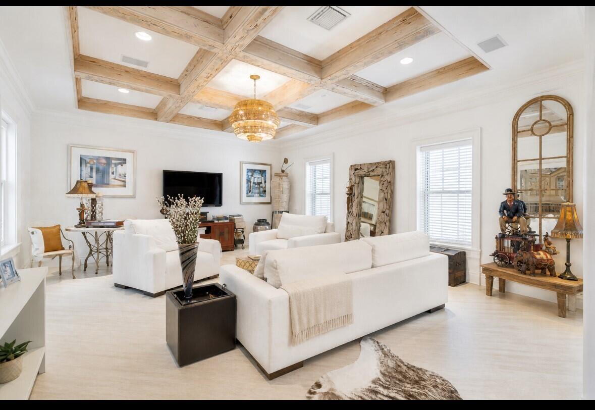 A bright living room features a coffered wood ceiling, white furniture, and a large chandelier — 286 Jamaica Lane, Palm Beach FL 33480, PALM BEACH, FL
