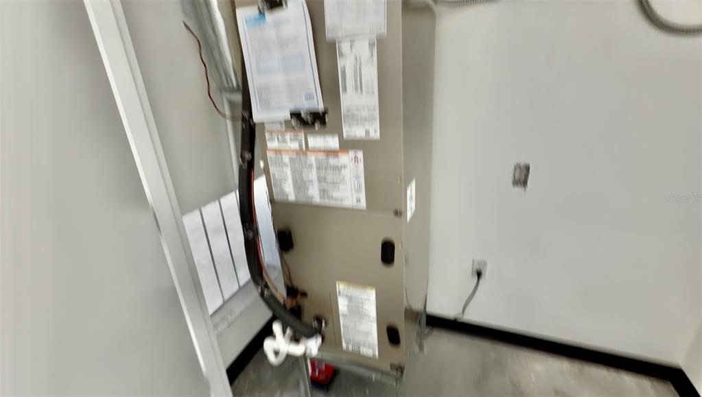 A vertical HVAC air handler unit stands in a utility closet with white walls — 727 TILLMAN PLACE UNIT 101, PLANT CITY, FL