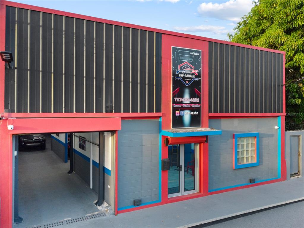 A commercial building with a red and gray facade, a garage entrance, and signage — 1195 DEL CARMEN STREET, SAN JUAN, PR