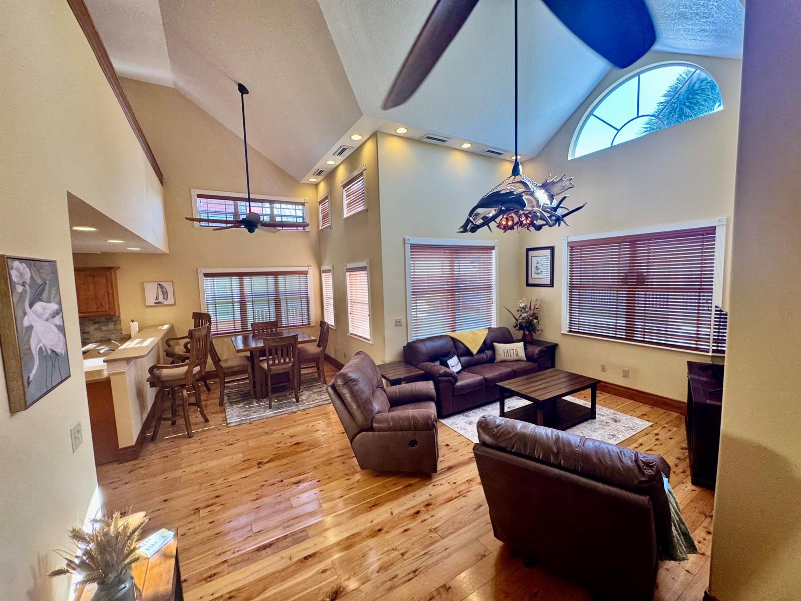 A living and dining area with vaulted ceilings, wood floors, and a rustic antler chandelier — 4334 Us Highway 441 Highway SE # 23, Okeechobee FL 34974, OKEECHOBEE, FL