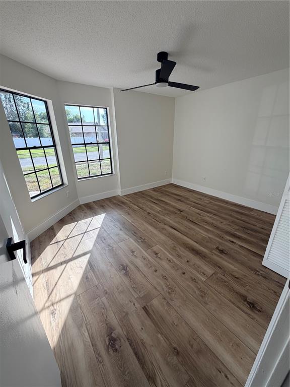 A bedroom with wood-look flooring, white walls, a ceiling fan, and two windows — 2943 WOOLRIDGE DRIVE, ORLANDO, FL
