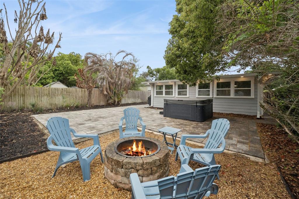 A backyard patio features a stone paver floor, outdoor seating, a dining set, and landscaping — 2513 MUSSELWHITE AVENUE, ORLANDO, FL