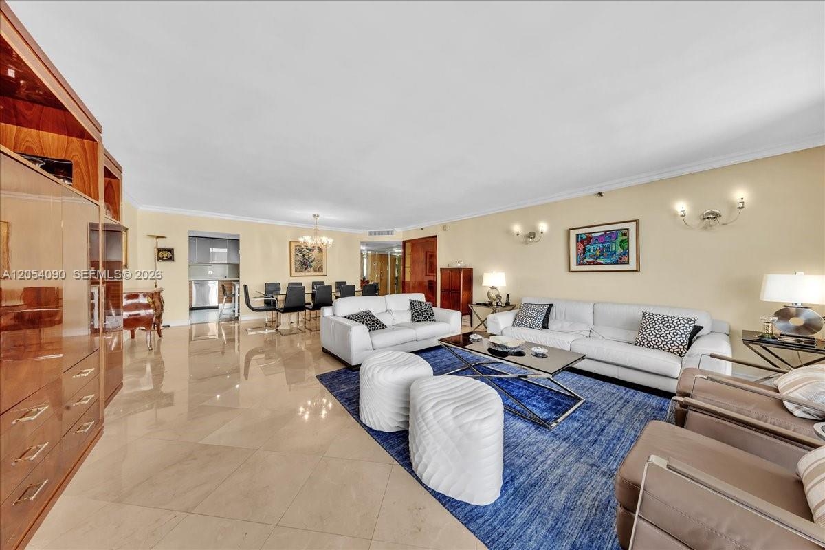 A spacious living room features light tile floors, white sofas, and a blue area rug — 8877 Collins Ave # 2, Surfside FL 33154, SURFSIDE, FL
