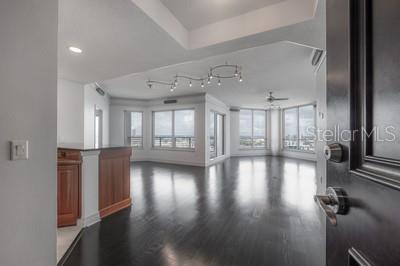An open-concept living area features dark hardwood floors, a wooden kitchen island, and large windows — 449 S 12TH STREET UNIT 2401, TAMPA, FL