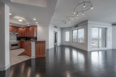 A kitchen with wood cabinets and a large open living area with dark hardwood floors — 449 S 12TH STREET UNIT 2401, TAMPA, FL