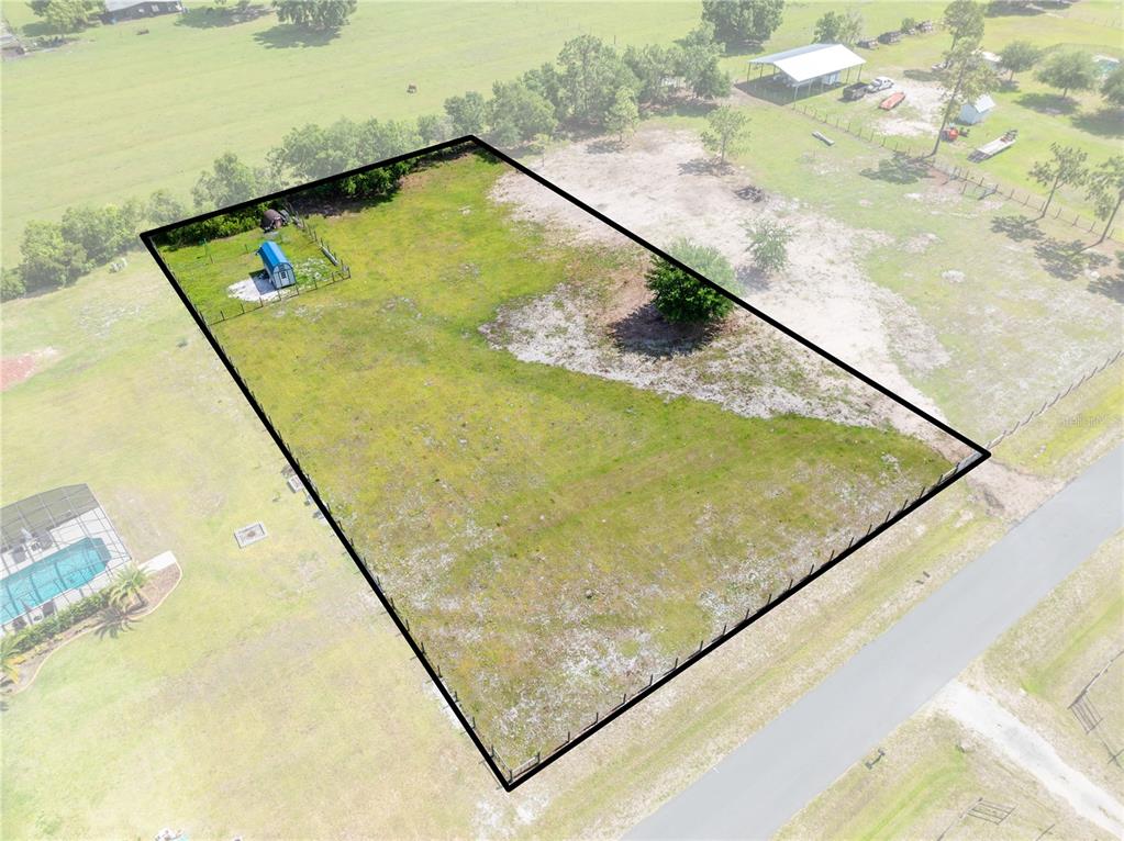 An aerial view shows a fenced, rectangular plot of land with a small shed — HUNTING LODGE DRIVE, ST CLOUD, FL