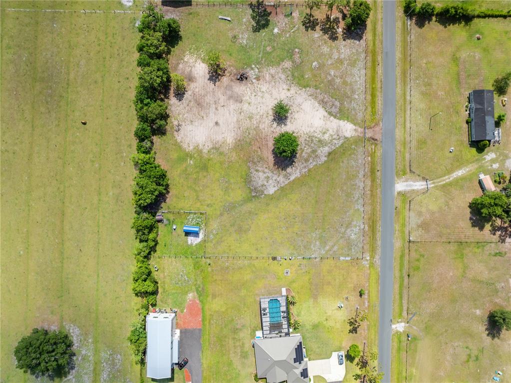 An aerial view shows a residential property with a house, pool, and large grassy lot — HUNTING LODGE DRIVE, ST CLOUD, FL