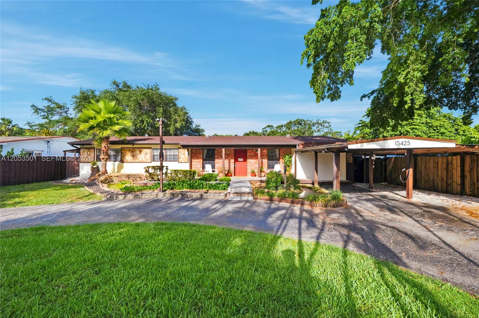 A single-story brick house features a front porch, a carport, and a landscaped yard — 15425 N Miami Ave, Miami FL 33169, MIAMI, FL