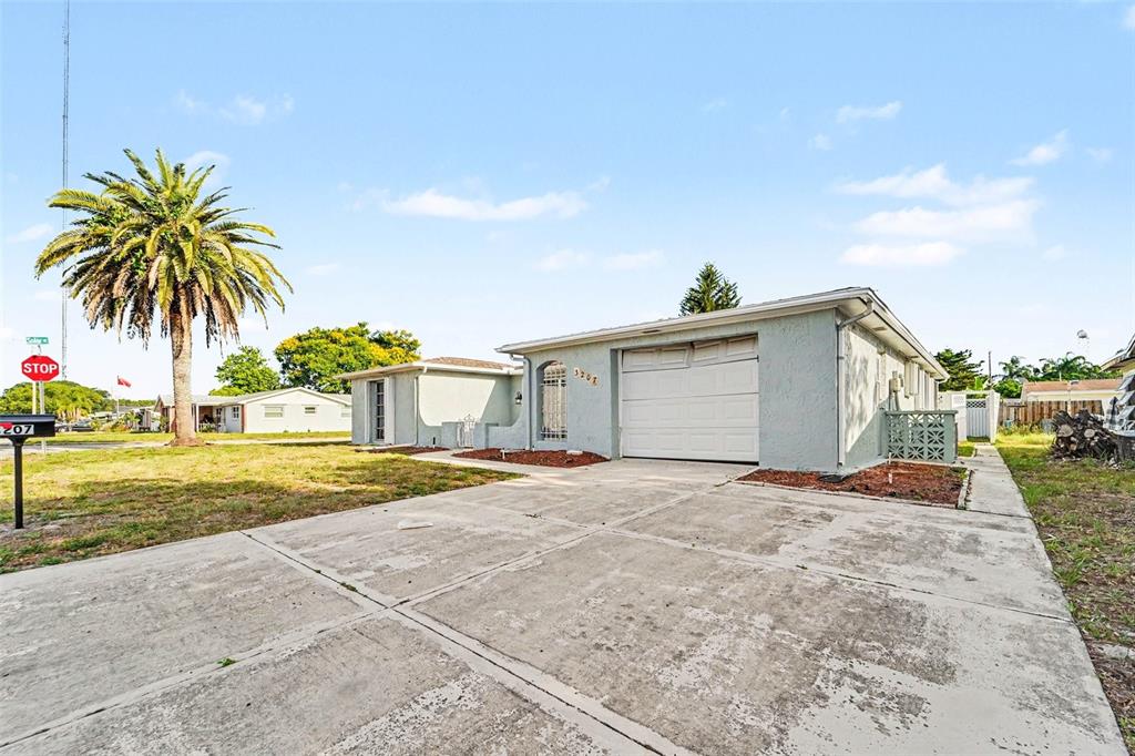 A single-story house with a light blue exterior, a one-car garage, and a concrete driveway — 3207 SALISBURY DRIVE, HOLIDAY, FL