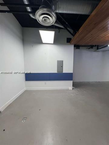 An interior view of an empty office space with a gray floor and exposed ceiling — 20200 W Dixie Hwy # 1008, Miami FL 33180, MIAMI, FL