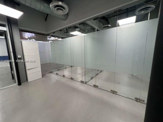 An office space features glass partitions, exposed ductwork, and a white storage cabinet — 20200 W Dixie Hwy # 1008, Miami FL 33180, MIAMI, FL
