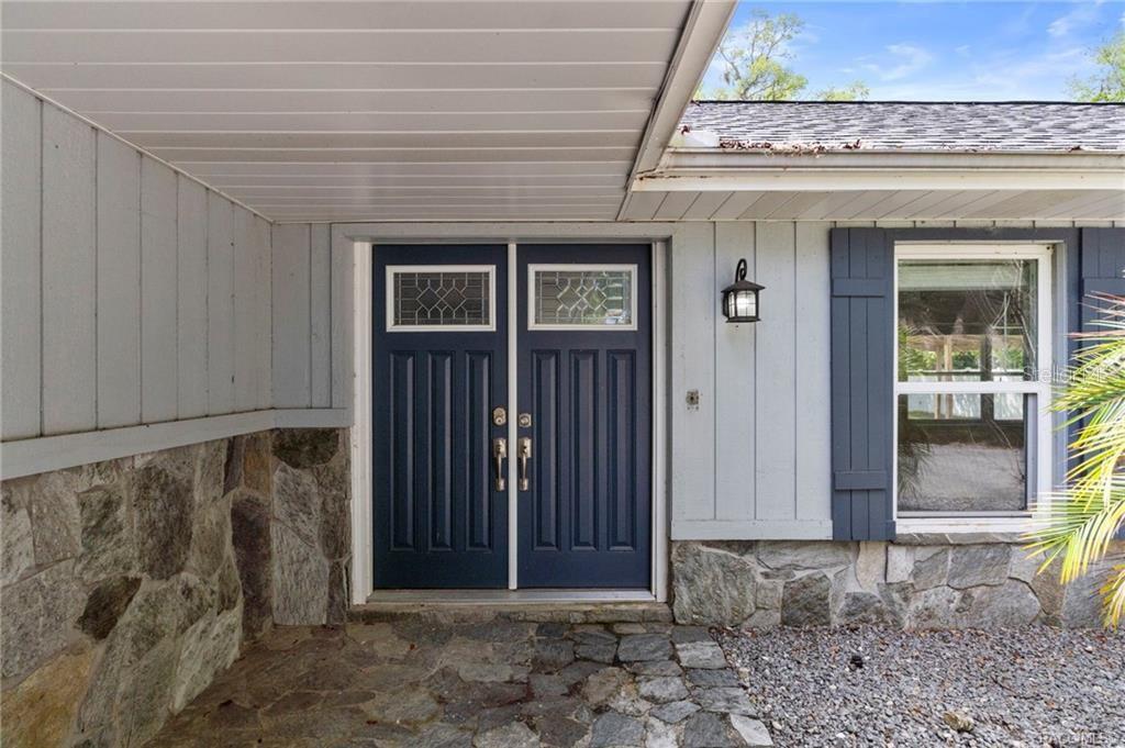A front entryway features double blue doors, stone siding, and a stone porch floor — 260 SE 16TH TERRACE, CRYSTAL RIVER, FL