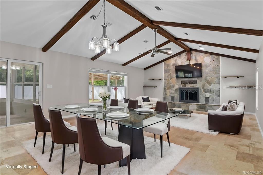 A dining and living area features a vaulted ceiling with exposed beams and stone fireplace — 260 SE 16TH TERRACE, CRYSTAL RIVER, FL