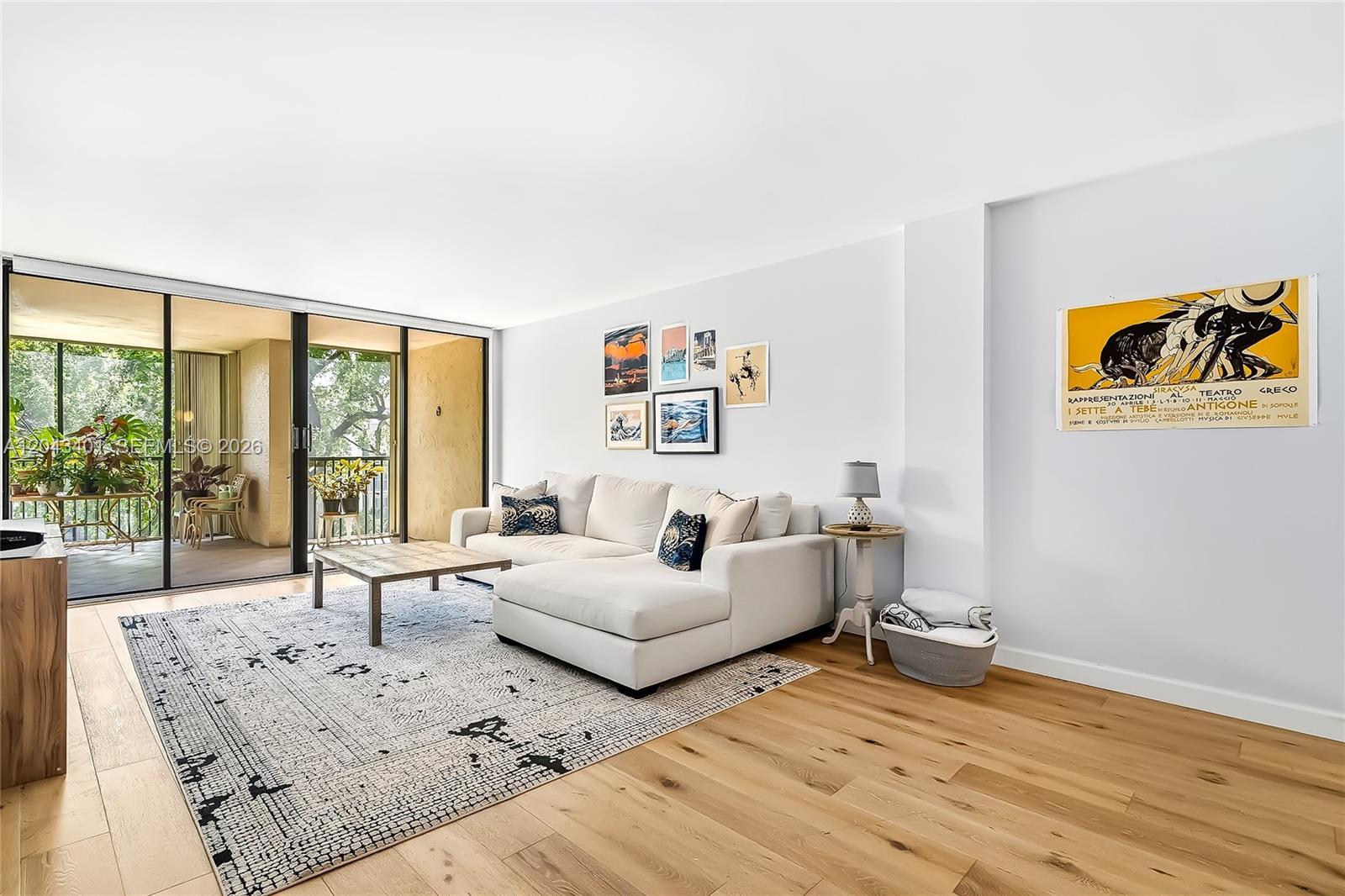 A living room features a white sectional sofa, a patterned rug, and a balcony view — 2808 N 46th Ave # E549, Hollywood FL 33021, HOLLYWOOD, FL