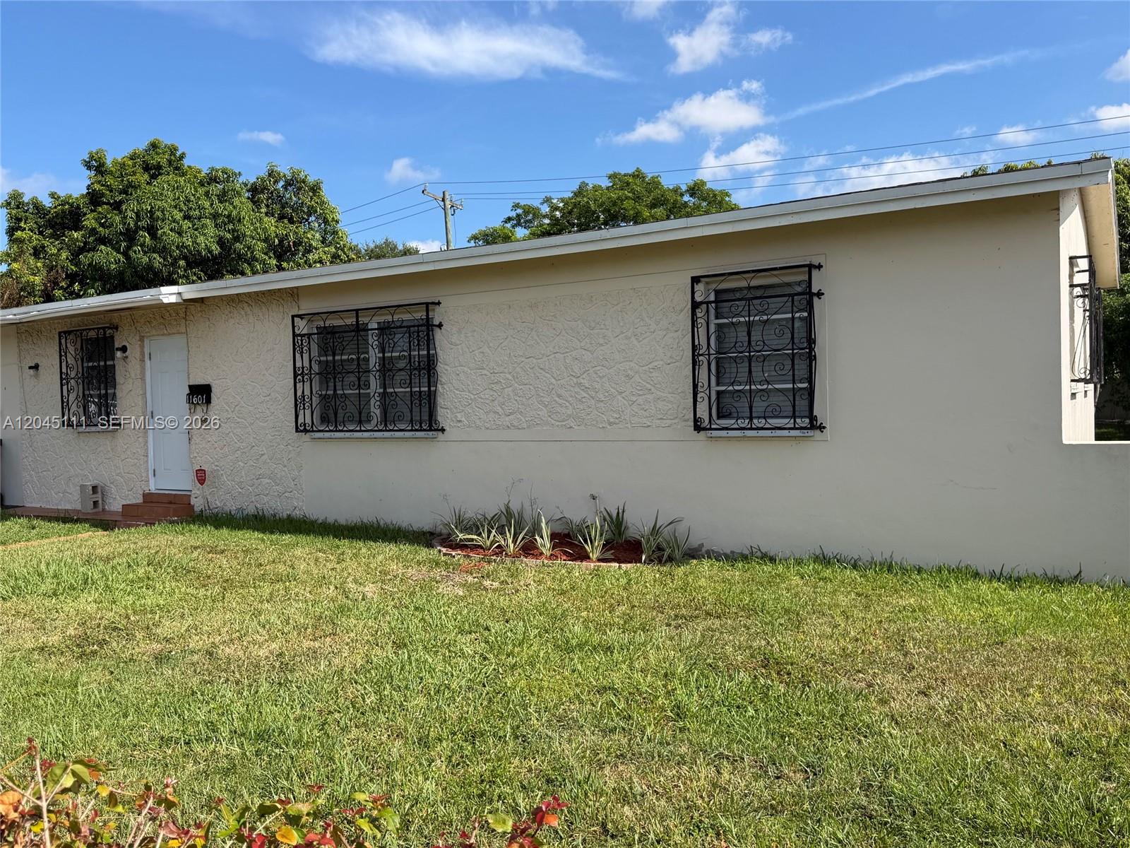 A single-story house with a textured facade, security bars on windows, and a front lawn — 11601 Pinkston Dr, Miami FL 33176, MIAMI, FL