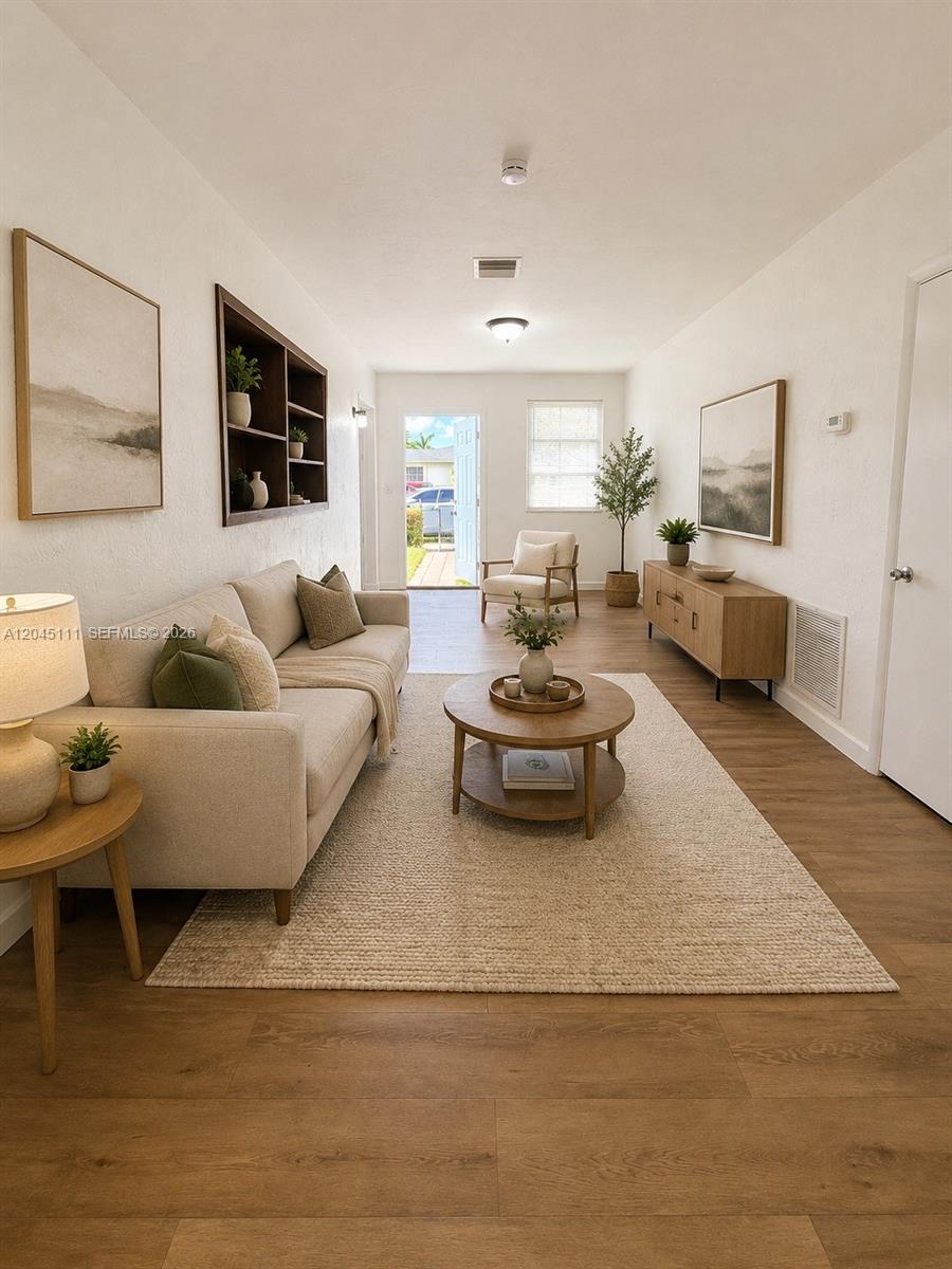 A living room features a beige sofa, round coffee table, and light wood flooring — 11601 Pinkston Dr, Miami FL 33176, MIAMI, FL