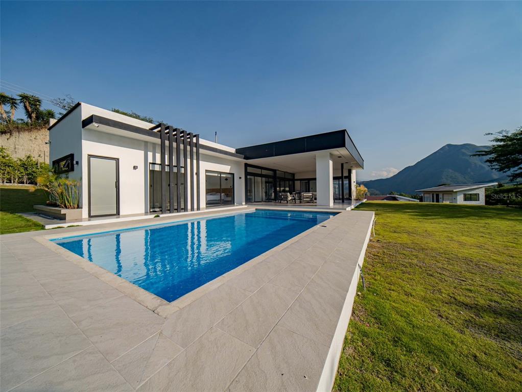 A modern white house with a swimming pool and a mountain view in the background — 00 CEIBOPAMBA BARRIO EL ALGODONAL, LOJA/ ECUADOR, NY