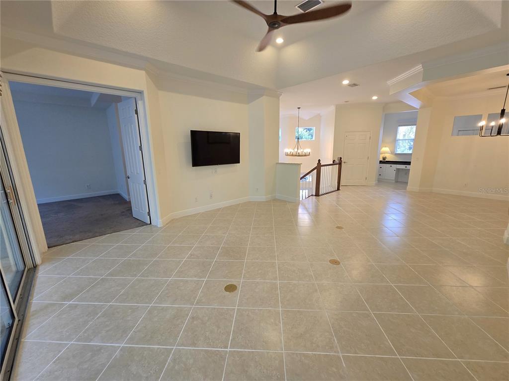 A spacious living area features tile flooring, a mounted television, and a ceiling fan — 4118 OSPREY HARBOUR LOOP, CORTEZ, FL