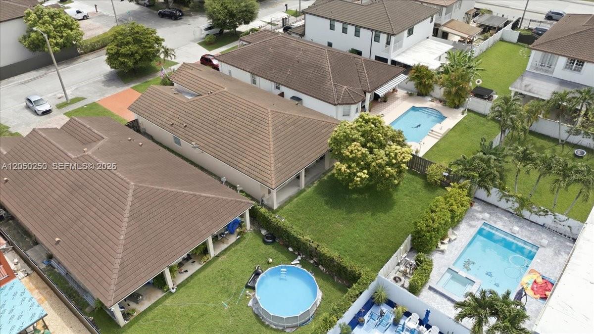 An aerial view shows several suburban houses with tiled roofs, swimming pools, and green lawns — 14623 SW 11th St, Miami FL 33184, MIAMI, FL