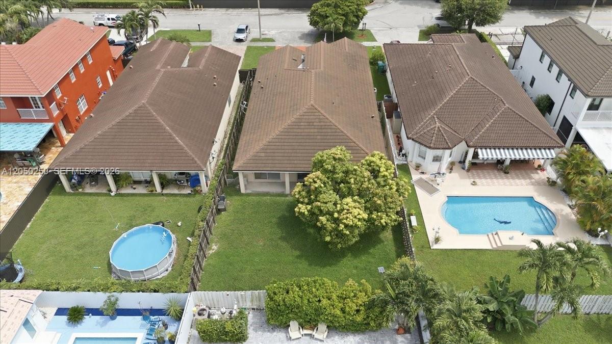 An aerial view shows three suburban houses with backyards, two featuring swimming pools — 14623 SW 11th St, Miami FL 33184, MIAMI, FL