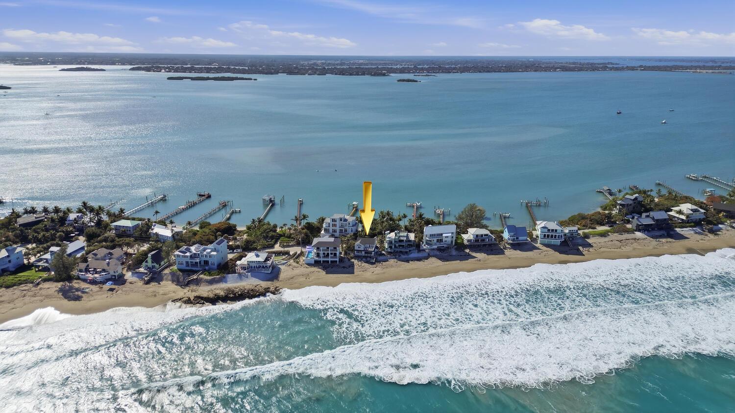 An aerial view shows a beachfront house marked by a yellow arrow along the coast — 1031 SE Macarthur Boulevard, Stuart FL 34996, STUART, FL