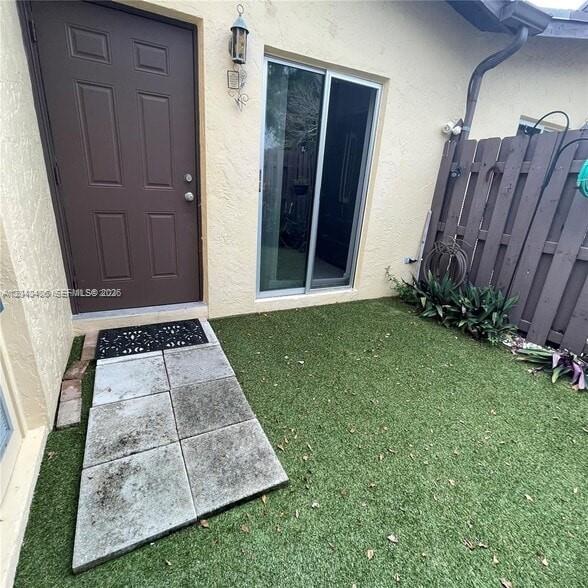 A brown door and sliding glass door open onto a small patio with artificial turf — 112 Fox Rd # 50, Hollywood FL 33024, HOLLYWOOD, FL