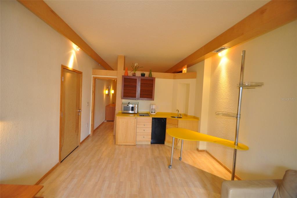 A small kitchen area features light wood cabinets, yellow countertops, and a yellow breakfast bar — 101 PALM HARBOR PARKWAY UNIT C230, PALM COAST, FL