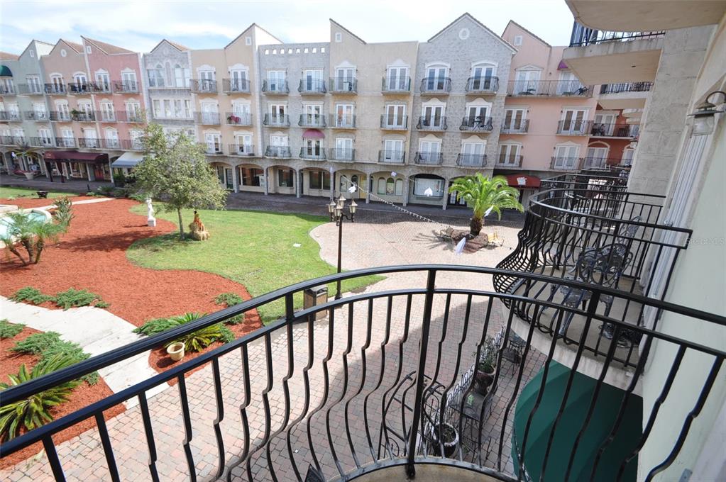 A view from a balcony overlooking a courtyard with a lawn and multi-story buildings — 101 PALM HARBOR PARKWAY UNIT C230, PALM COAST, FL