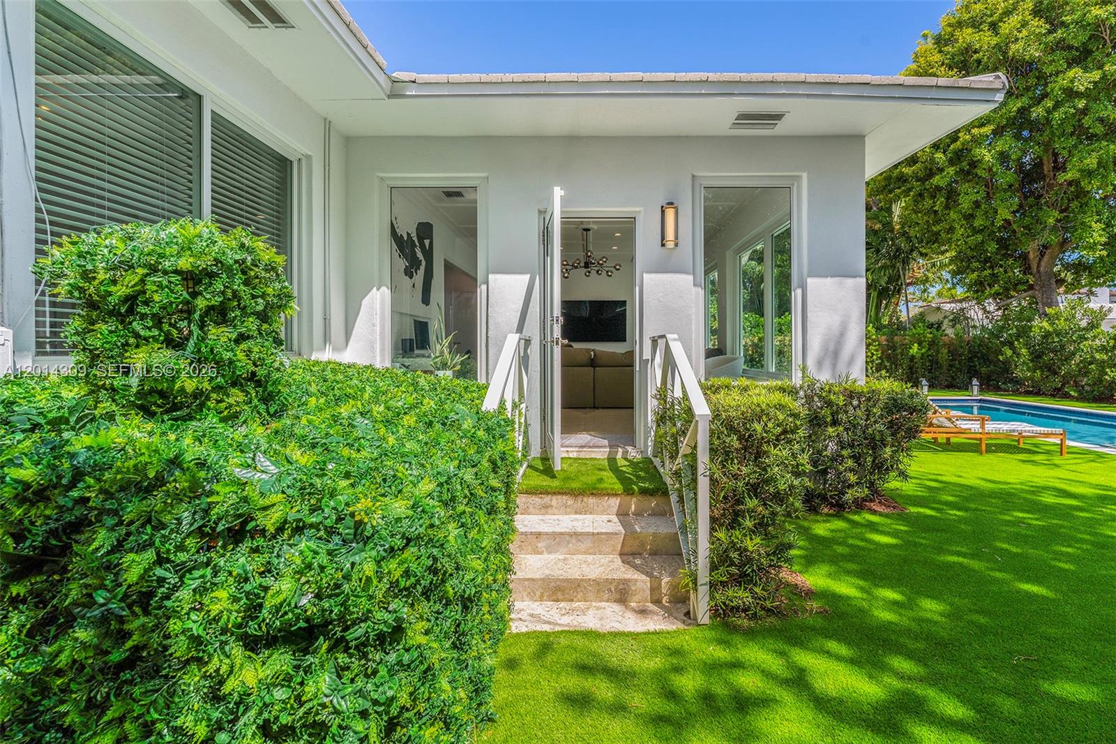 A white house exterior features a set of stone steps leading to an open doorway — 6145 La Gorce Dr, Miami Beach FL 33140, MIAMI BEACH, FL
